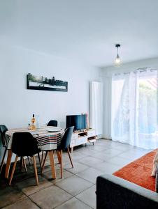 a living room with a table and chairs and a tv at Euskal Herria in Saint-Pée-sur-Nivelle +2 photos
