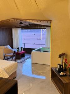 a bedroom with a bed and a tub in a room at Wadi Rum Lana luxury camp in Wadi Rum