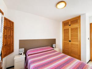 a bedroom with a bed with a striped blanket at Stay in Costa Hispania in Santa Pola
