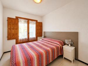 a bedroom with a bed with a striped bedspread and a window at Stay in Costa Hispania in Santa Pola +36 photos