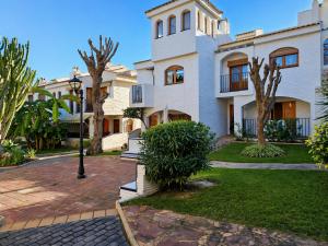 a large white house with trees in front of it at Stay in Costa Hispania in Santa Pola