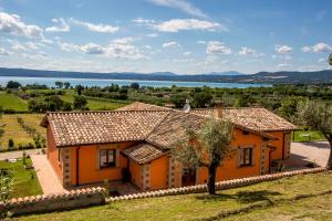 an orange house with a view of a lake at Agriturismo Parco di Canuleio in Bolsena