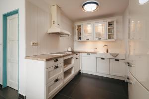 a white kitchen with white cabinets and a sink at Bezdrevská Bašta in České Budějovice