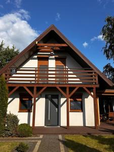 a house with a gambrel roof with a porch at Domek nad jeziorem Kamionki Małe in Kamionki Małe +7 photos