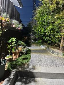 a garden path with potted plants on the side of a building at Guest House "Ro"kumano in Shimonoseki