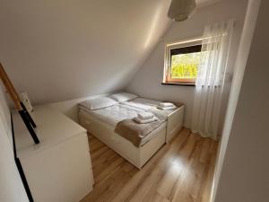 a small bedroom with a bed and a window at Domek nad jeziorem Kamionki Małe in Kamionki Małe