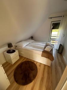 a bedroom with a bed and a wooden floor at Domek nad jeziorem Kamionki Małe in Kamionki Małe