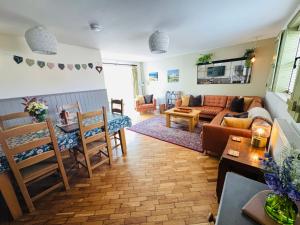 a living room with a couch and a table at Vale View Cottages - The Stables in Prestatyn