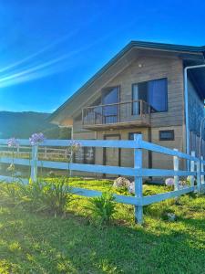 a house with a blue fence in front of it at Poas Green Chalets in Fraijanes