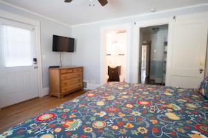 a bedroom with a bed and a dresser and a television at Swamp Rabbit Inn TR in Travelers Rest
