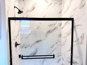 a shower with a glass door in a bathroom at Charming Lake Front Home and Pavilion in Milledgeville +93 photos