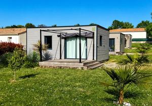 a tiny house with a porch in a yard at Les Logis de la Seugne in Saint-Germain-de-Lusignan