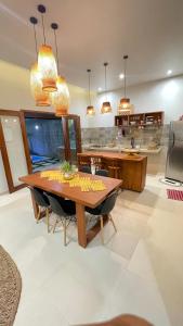 a kitchen with a wooden table and chairs at CASA TEMPORADA BARREIRINHAS Yellow 3 in Barreirinhas