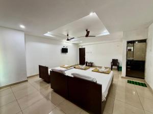 a bedroom with a bed and a ceiling at Hotel Sai in Udupi +8 photos
