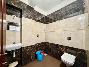 a bathroom with a toilet and a sink at Hotel Sai in Udupi