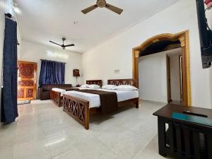 a bedroom with two beds and a flat screen tv at Nanasu Home stay in Malpe +15 photos