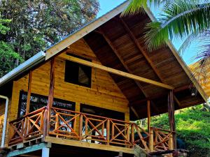 a wooden cabin with a porch and a roof at The Pause EcoCabin Bocas del Toro in Bocas Town