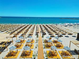 a beach with chairs and umbrellas and the ocean at Tomis Villa Center Studio in Constanţa