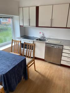 a kitchen with a table and chairs and a sink at 40 kvm lejlighed in Kjellerup +7 photos