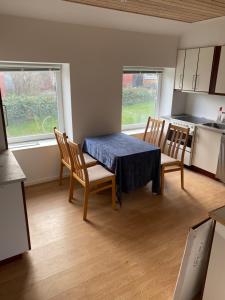 a kitchen with a table and chairs in a room at 40 kvm lejlighed in Kjellerup
