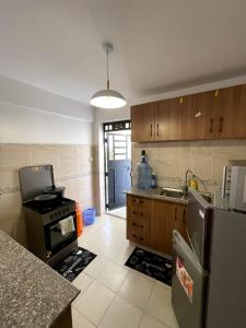 a kitchen with a refrigerator and a stove top oven at Bay Loft 1 Br Netflix Lake Views, Starlink in Homa Bay