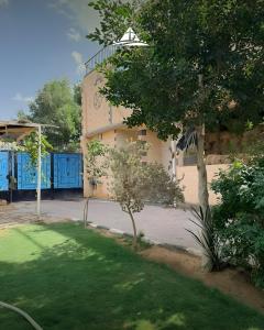 a building with a tree in front of a yard at Pyramids Green View in Cairo