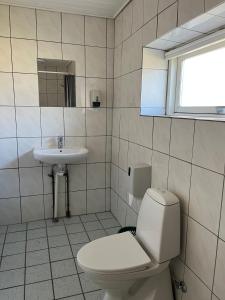a bathroom with a toilet and a sink at Hotel Færgelunden in Jægerspris