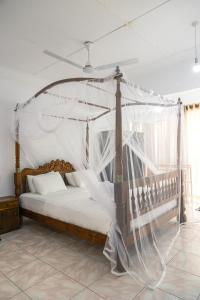 a bedroom with a canopy bed with mosquito net at Edelweiss Resort in Mirissa +78 photos