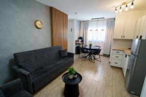 a living room with a couch and a table and a kitchen at צימר אדל - Zimmer Adel in Yavneʼel