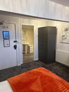 a bedroom with an orange rug and a black cabinet at Fox lodge in Blackpool +42 photos