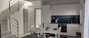 a kitchen with a white table and chairs in a room at Apartman TUSUM Ražanac in Ražanac