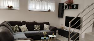 a living room with a brown couch and a table at Apartman TUSUM Ražanac in Ražanac