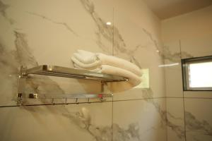 a towel rack with towels on a wall in a bathroom at Wanderlust Villas in Pinangode +66 photos