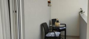 a table and two chairs and a table with a purse on it at Apartman TUSUM Ražanac in Ražanac