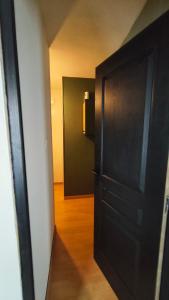 a black door in a room with a hallway at Chambre 1 in Aniche