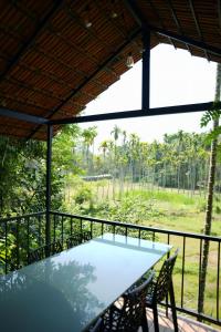 a table and chairs on the balcony of a house at Wanderlust Villas in Pinangode