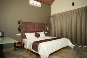 a bedroom with a large bed and a desk at Wanderlust Villas in Pinangode