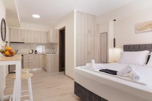 ein Schlafzimmer mit einem weißen Bett und eine Küche in der Unterkunft Plaka Studios 3 in Benitses + 7 Fotos