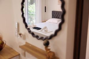 ein Spiegel, der ein Bett in einem Zimmer reflektiert in der Unterkunft Plaka Studios 3 in Benitses