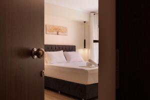 ein Schlafzimmer mit einem Bett mit weißen Laken und weißen Kissen in der Unterkunft Plaka Studios 3 in Benitses