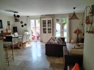 a living room with a couch and a table at Villa Luberon Piscine Pétanques in Cavaillon