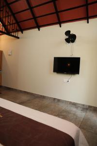 a white wall with a flat screen tv on a wall at Wanderlust Villas in Pinangode