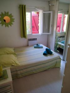 a bedroom with a bed with two blue shoes on it at Villa Luberon Piscine Pétanques in Cavaillon +13 photos