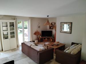 a living room with two couches and a television at Villa Luberon Piscine Pétanques in Cavaillon