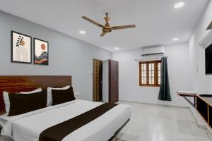 a bedroom with a bed and a ceiling fan at Super Hotel O iva Holiday inn in Maula Ali