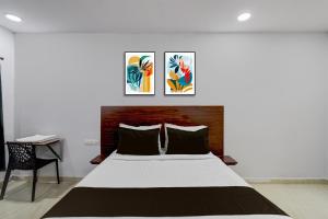 a bedroom with a large bed and three paintings on the wall at Super Hotel O iva Holiday inn in Maula Ali