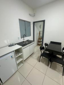 a kitchen and dining room with a table and a sink at Apto Centro Arapiraca in Arapiraca
