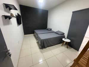 a small room with a bed and a table in it at Apto Centro Arapiraca in Arapiraca