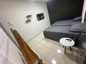 a room with a bed and a table and a staircase at Apto Centro Arapiraca in Arapiraca