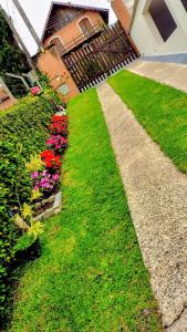 a garden with colorful flowers and a house at Chalés e suítes lima in Monte Verde
